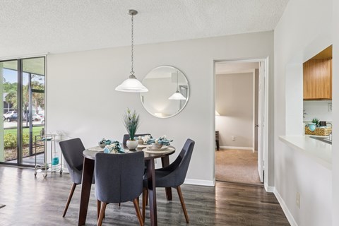 A dining room with a table set for two and a large window.