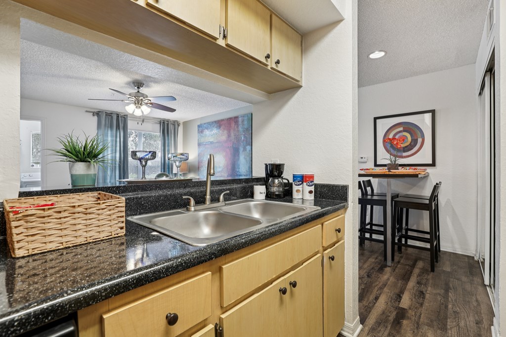 A kitchen with a black countertop and wooden cabinets. at University Park Apartments, Florida