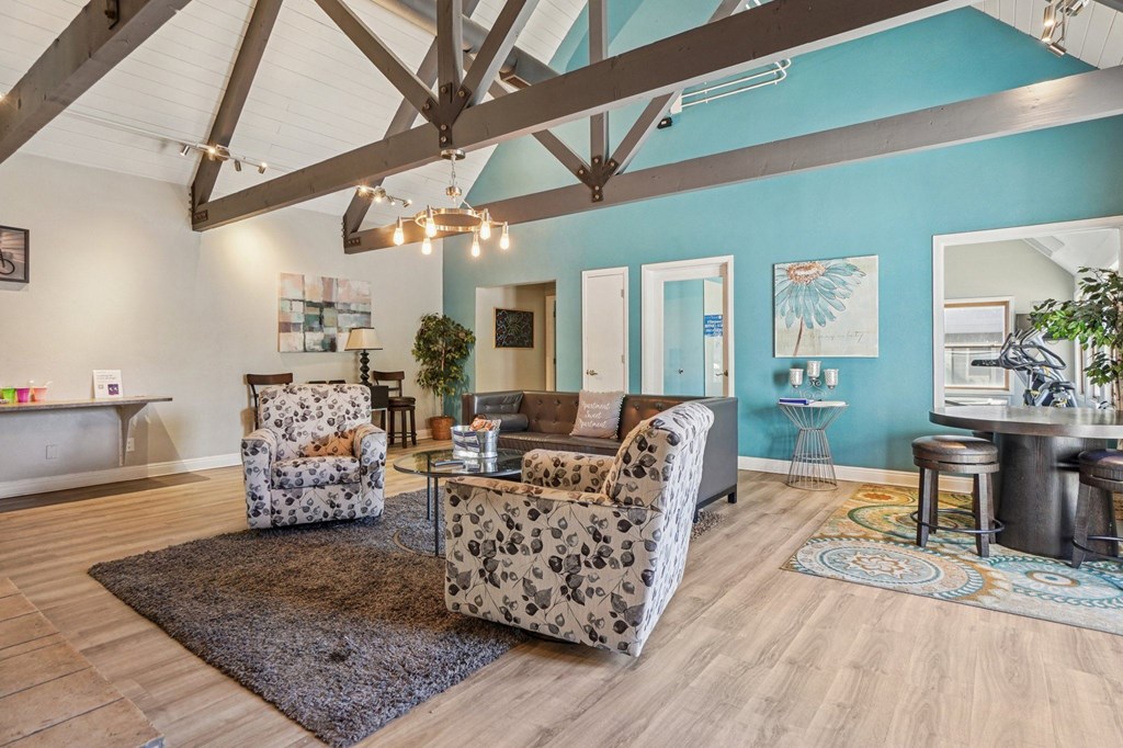 A living room with a wooden floor and a large mirror on the wall.
