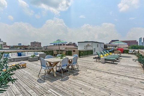 Rooftop deck with tables and chairs and a city in the background  at The View at Old City, Philadelphia