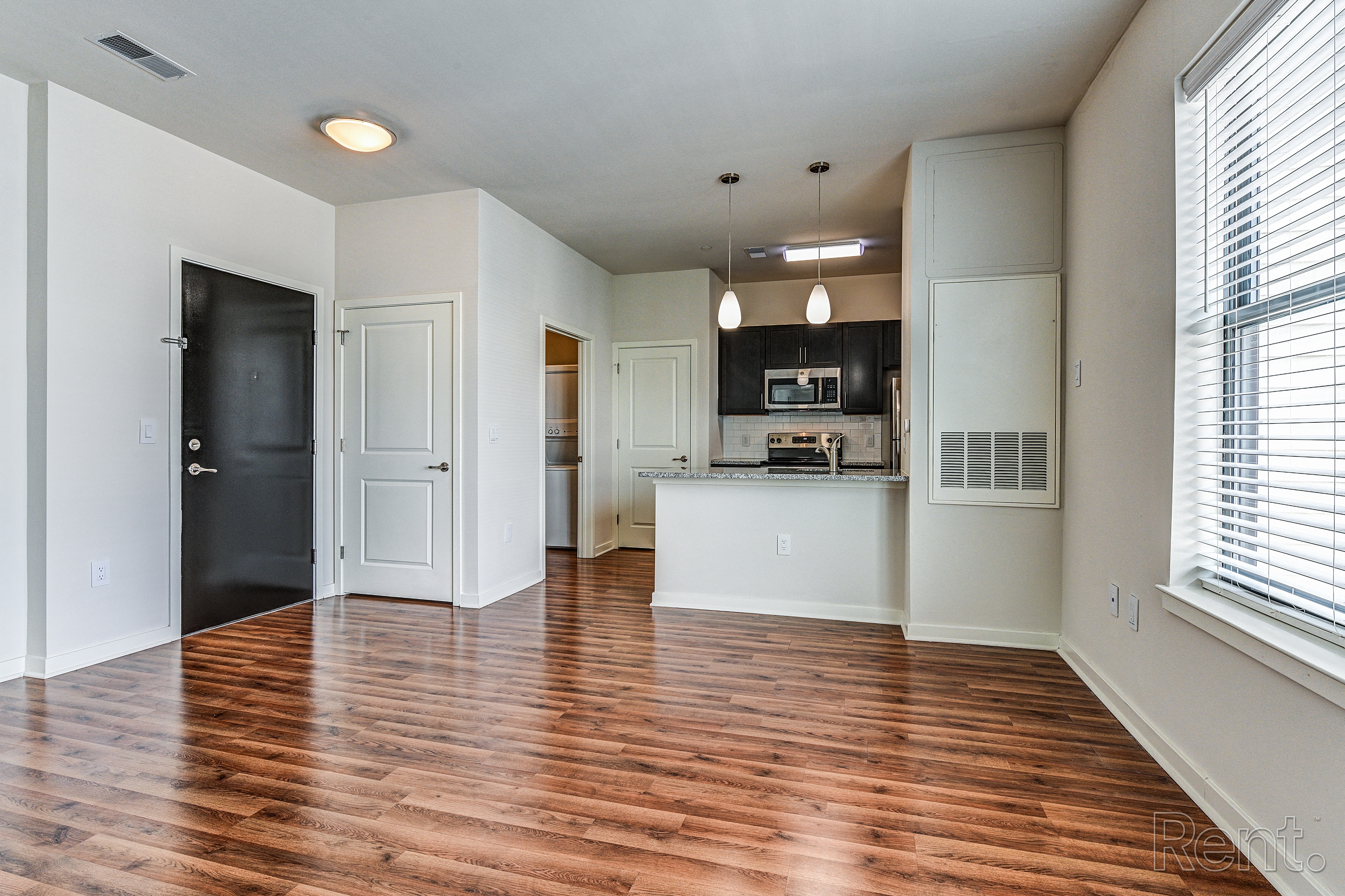 An empty living room with a kitchen in the background  at The View at Old City, Philadelphia