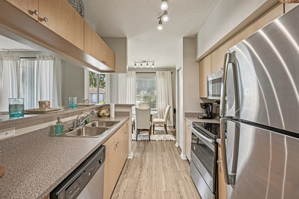 A modern kitchen with a large refrigerator and stainless steel appliances. at Heritage Bay, Jensen Beach, FL, 34957