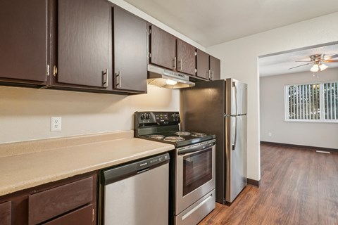 A kitchen with dark brown cabinets and stainless steel appliances.