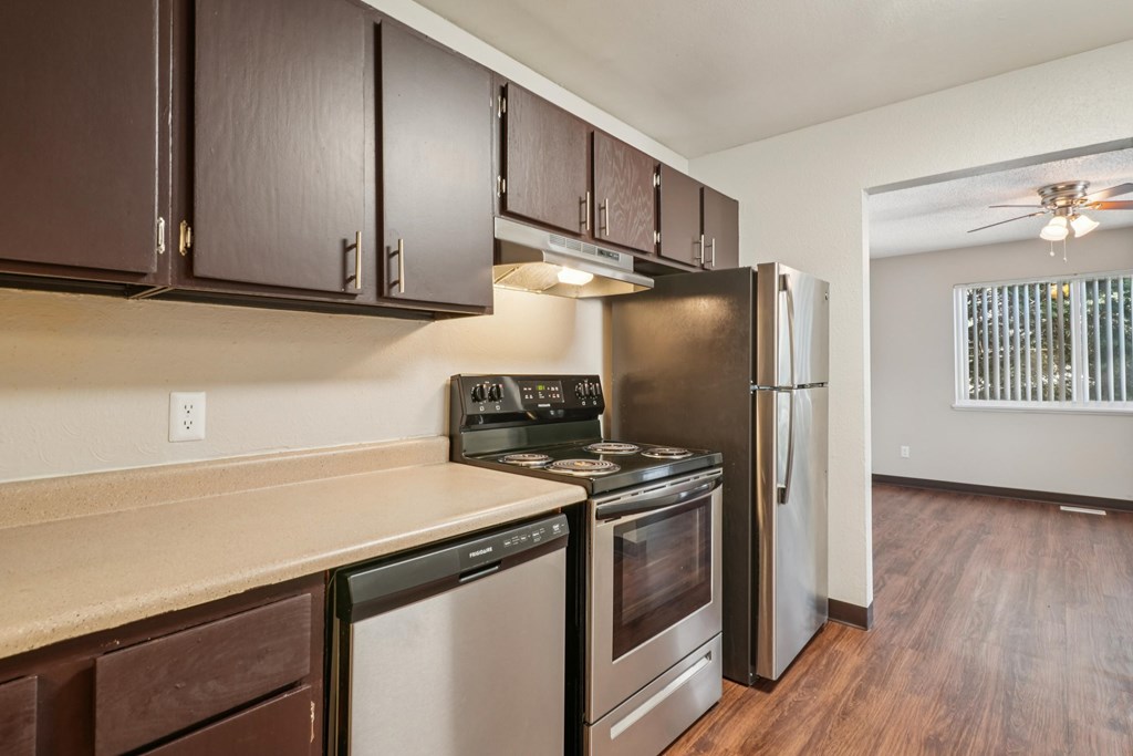 A kitchen with dark brown cabinets and stainless steel appliances.