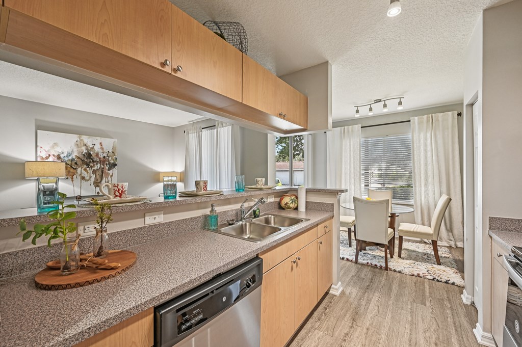 A kitchen with a granite counter top and stainless steel appliances. at Heritage Bay, Jensen Beach, FL