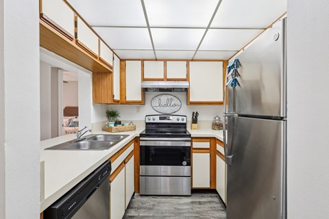 A kitchen with a stainless steel refrigerator and a stove top oven.