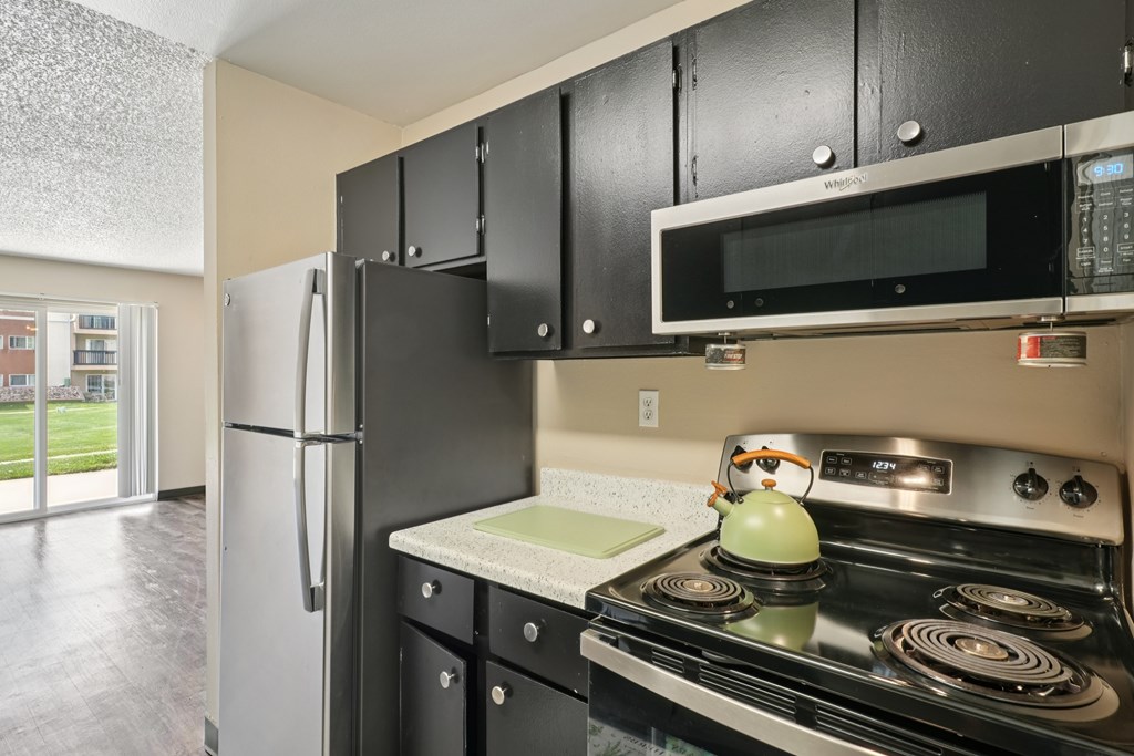 A black kitchen with a stove, microwave, and refrigerator. at Broadmoor Springs, Colorado, 80906