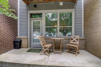 Apartment unit patio with two chairs and a table - Photo Gallery 4