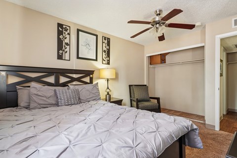A bedroom with a large bed and a ceiling fan.