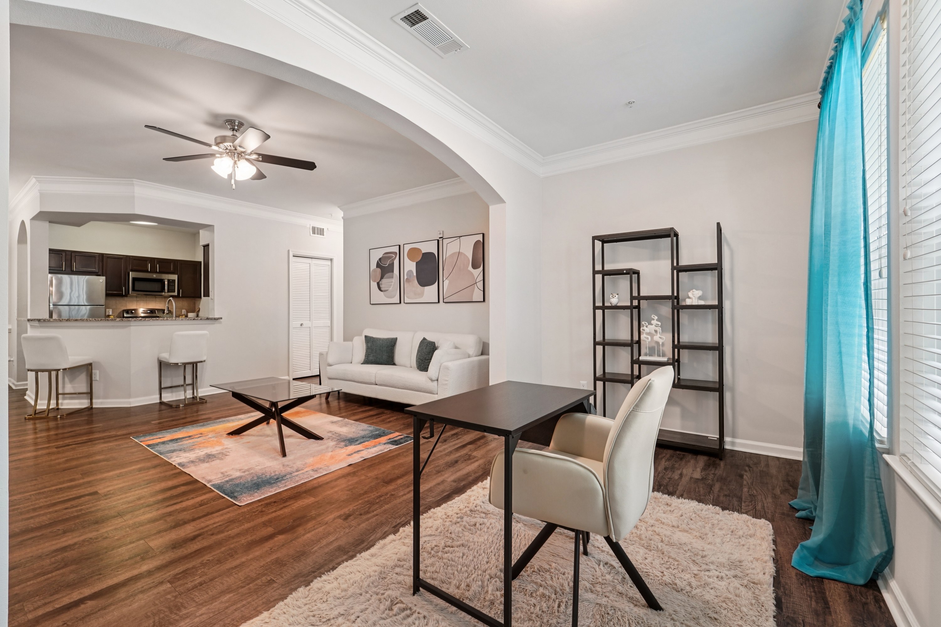 A modern living room with a black table and white chairs.