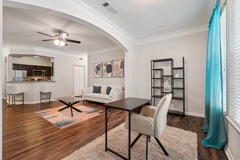 A modern living room with a black table and white chairs.