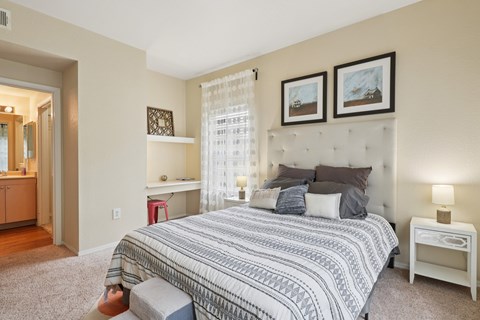 A bedroom with a large bed and a nightstand.