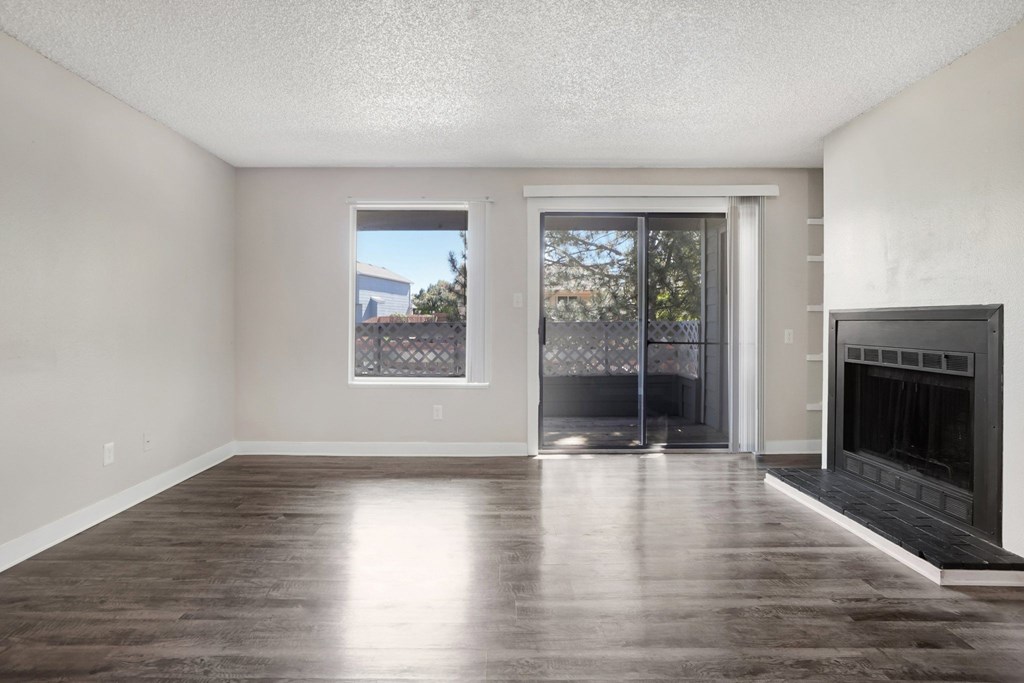 A room with a fireplace and sliding glass doors.