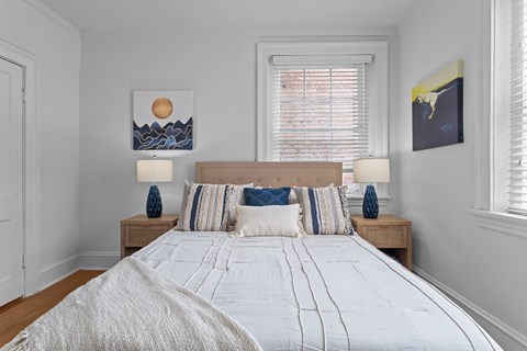 A bedroom with a large bed and two lamps on side tables.