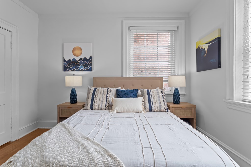A bedroom with a large bed and two lamps on side tables.