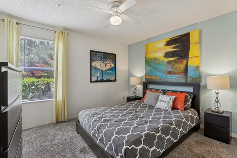 A bedroom with a large bed and a painting on the wall.