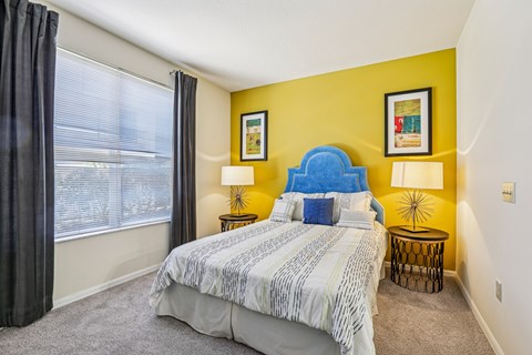 A bedroom with a large bed and a blue headboard.