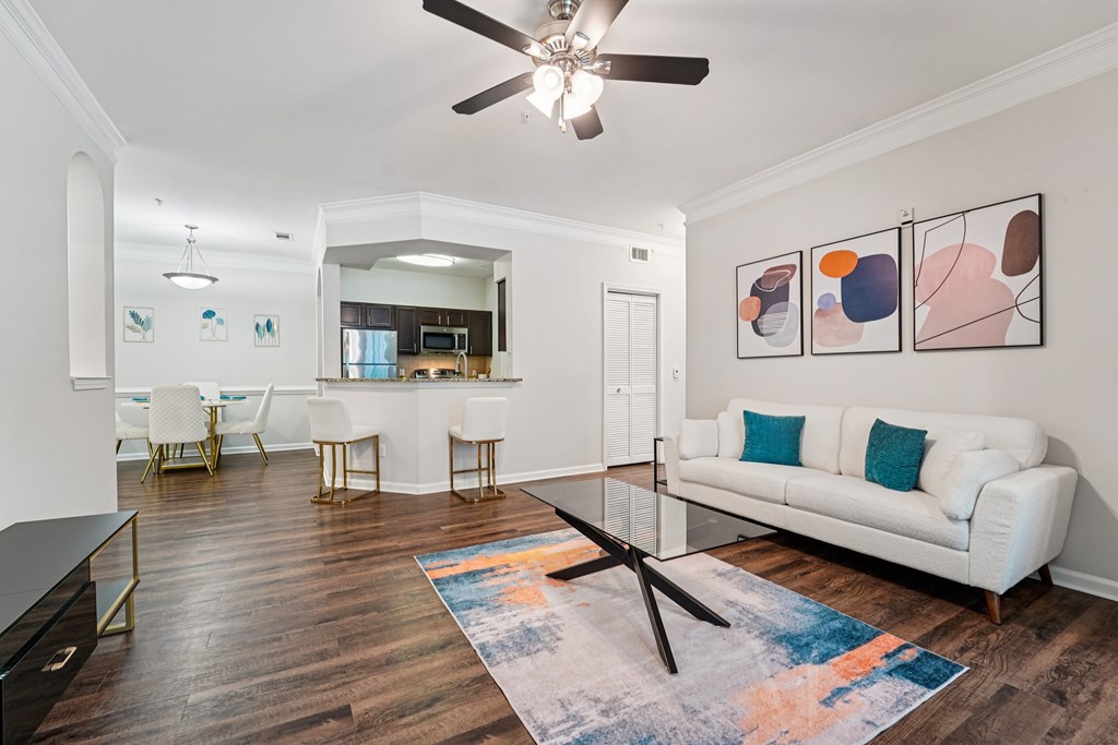 A living room with a white couch, a coffee table, and a ceiling fan.at Kingwood Glen, Kingwood, TX, 77339