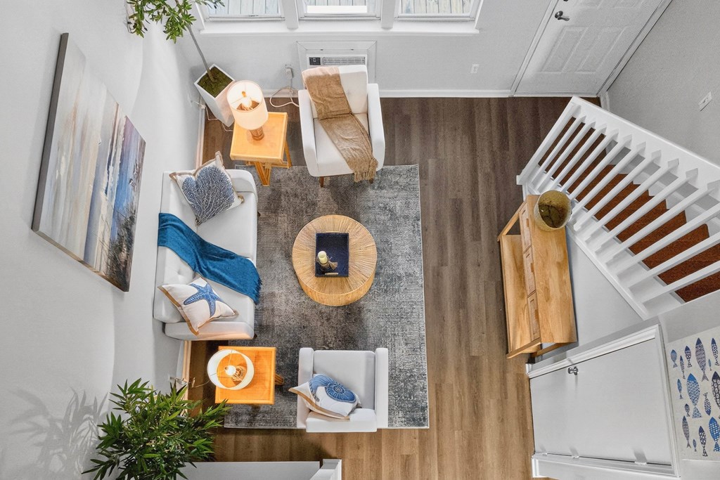 A living room with a couch, a coffee table, and a staircase.at Lofts of Wilmington, Wilmington, NC, 28405