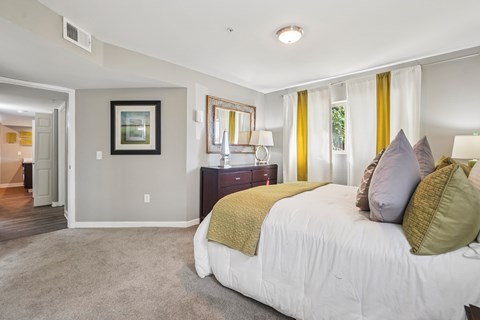 A bedroom with a large bed and a painting on the wall.