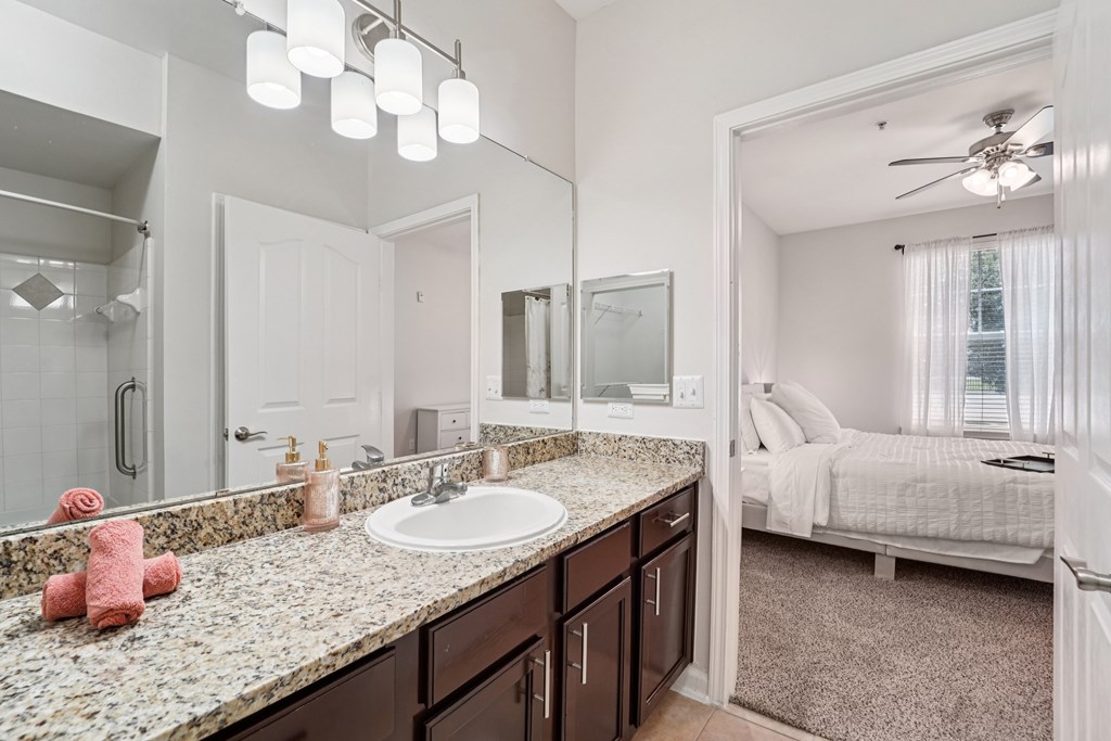 A bathroom with a sink, mirror, and bed.at Kingwood Glen, Kingwood, 77339