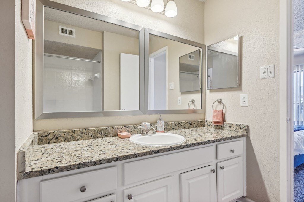 a bathroom with a sink and a mirror at The Glen at Highpoint, Dallas, 75243