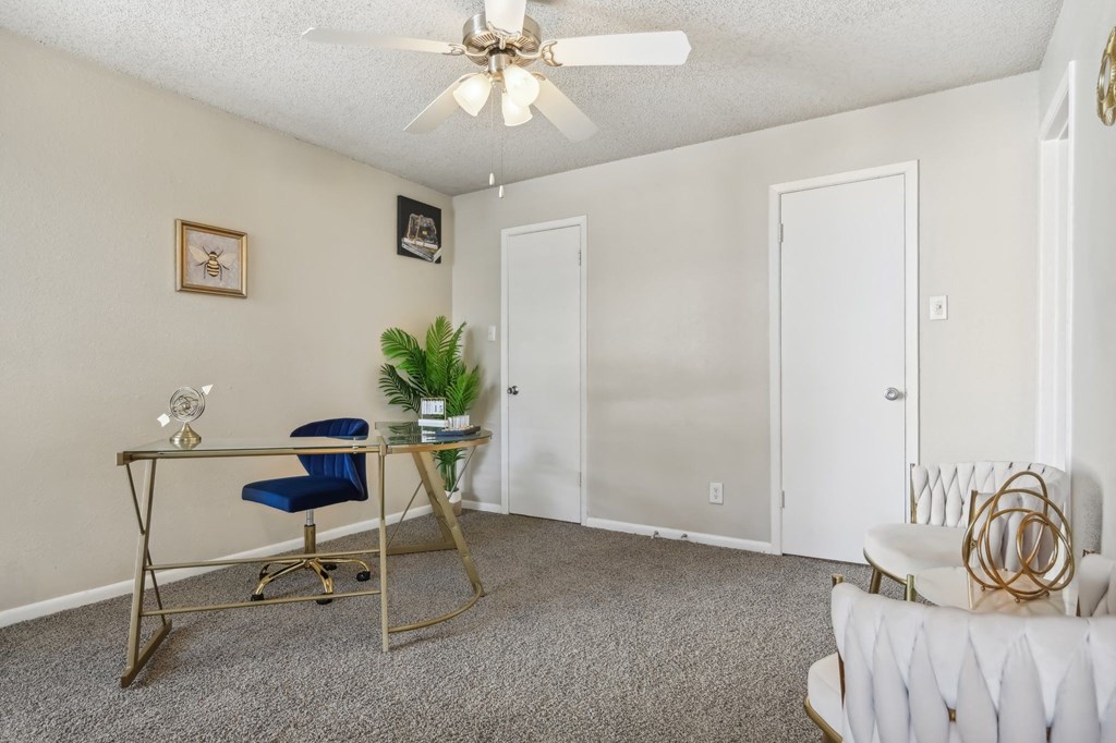 a living room with a desk and a ceiling fan at The Glen at Highpoint, Dallas, 75243
