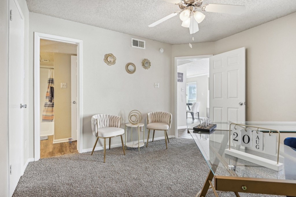 a living room with a glass table and chairs and a ceiling fan at The Glen at Highpoint, Dallas, 75243