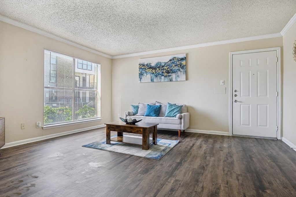 the living room of an apartment with a couch and a coffee table at The Glen at Highpoint, Dallas, 75243