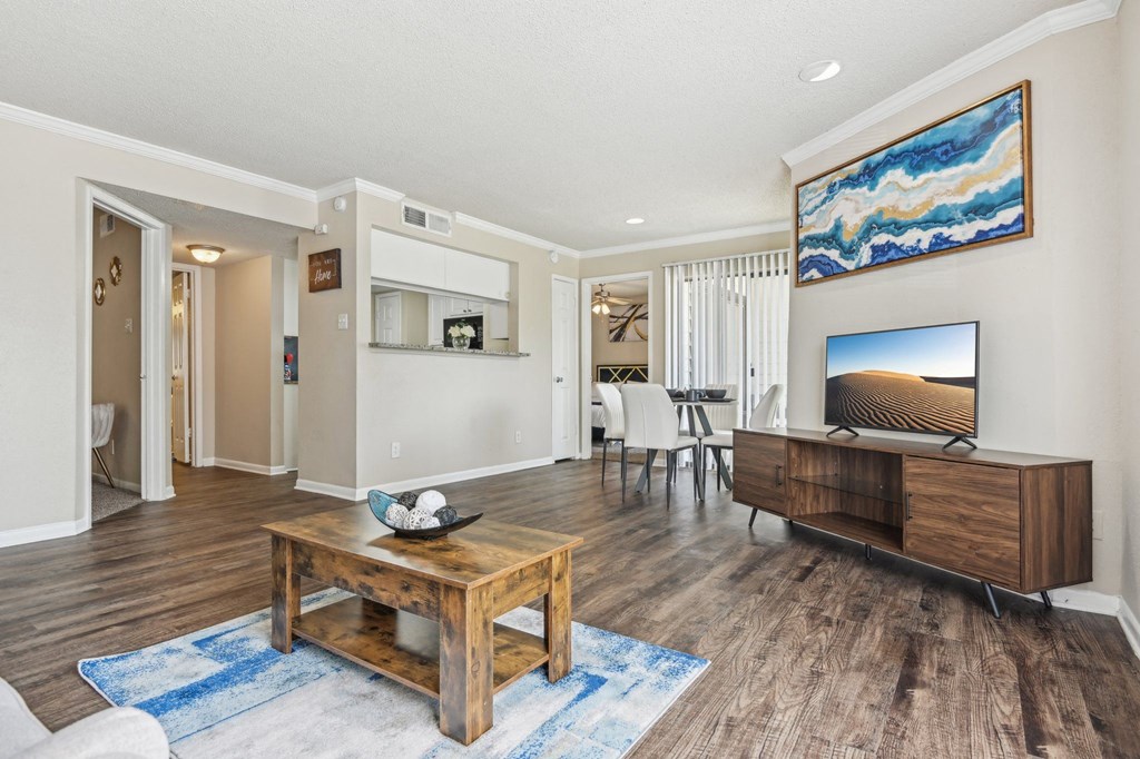 a living room with a table and a television at The Glen at Highpoint, Dallas, 75243