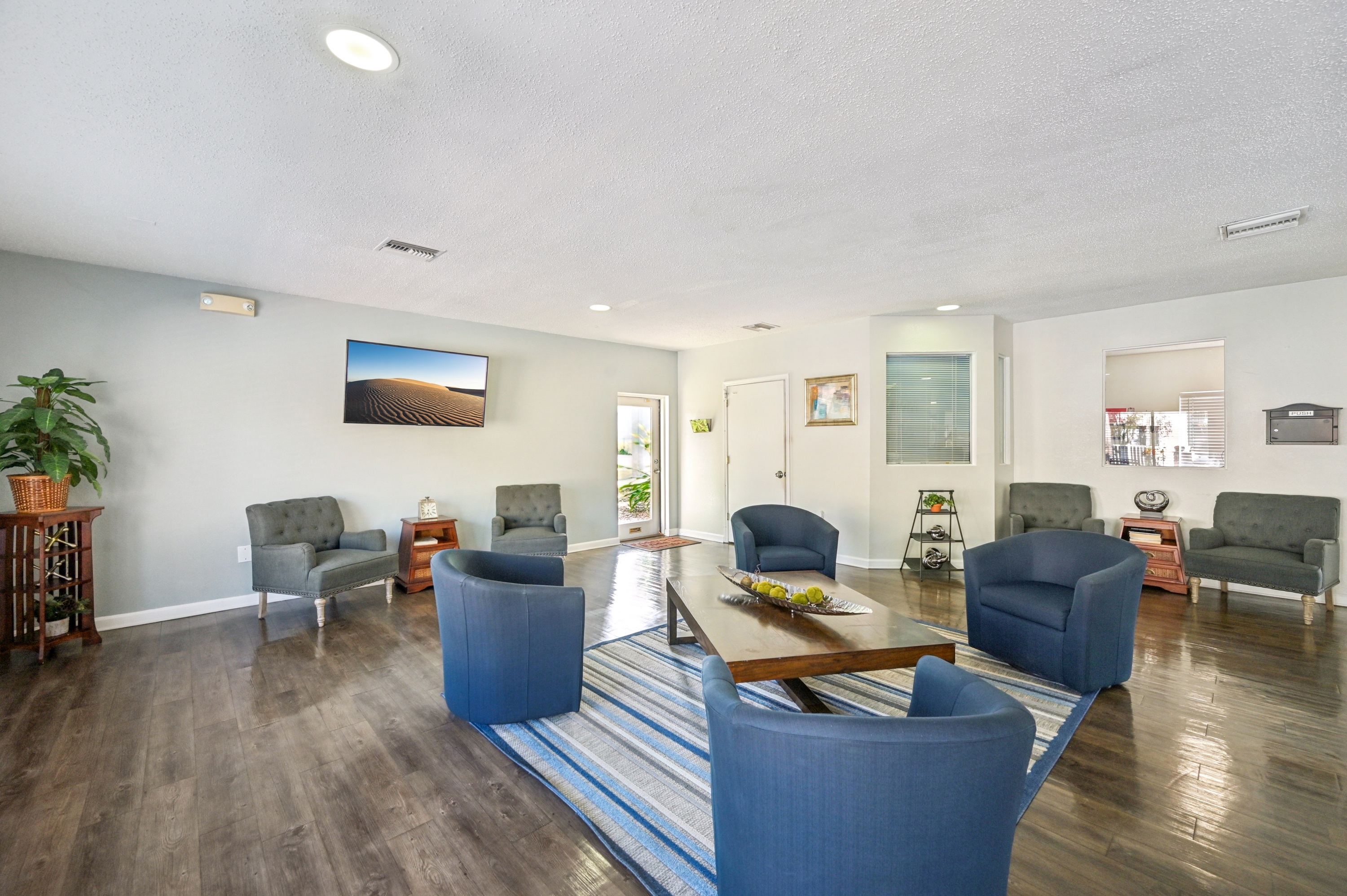 A living room with a blue couch and a wooden coffee table.