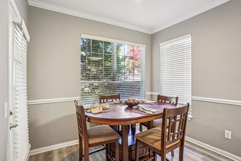 A dining room with a table set for four.