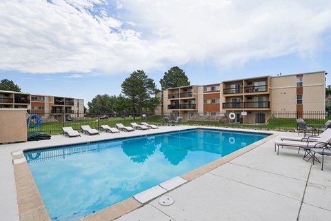 A swimming pool in front of apartment buildings.