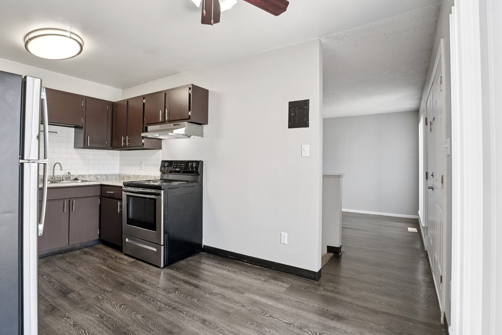 A kitchen with brown cabinets and a black fridge.at Aspen Townhomes, Colorado Springs, Colorado