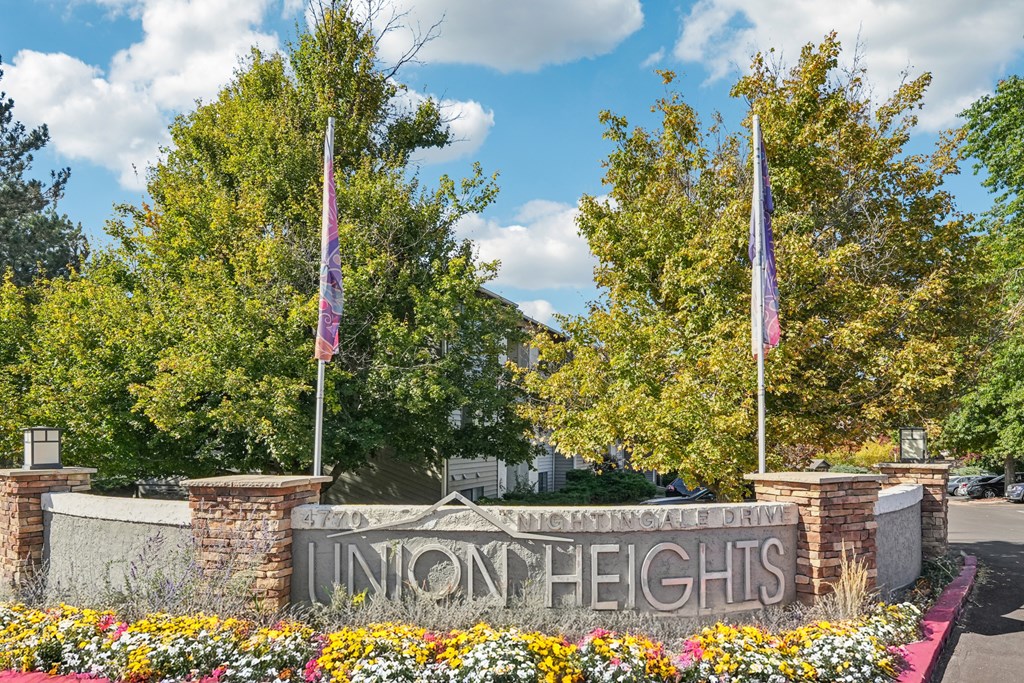 A sign that says Union Heights is in front of some trees.