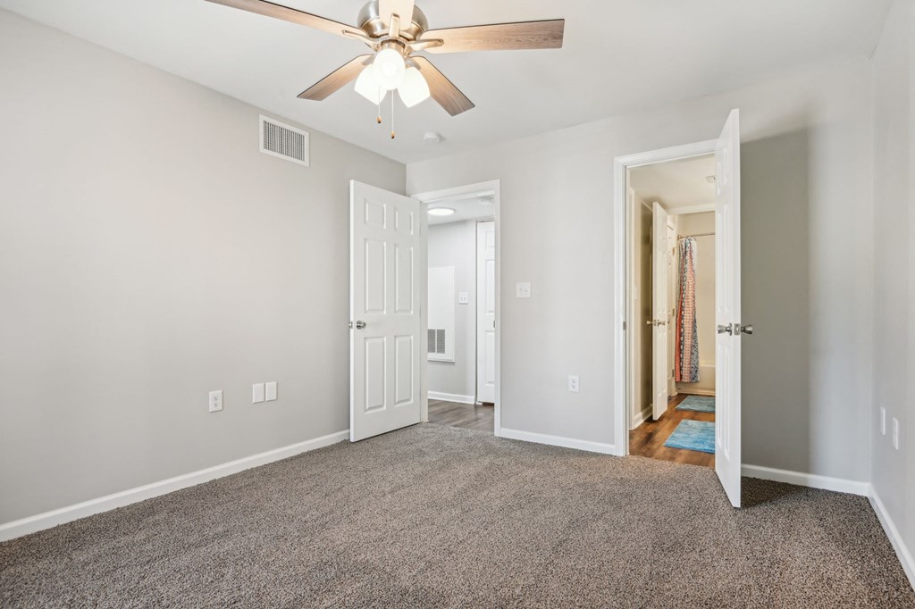 a living room with carpet and a ceiling fan at The Glen at Highpoint, Dallas, 75243