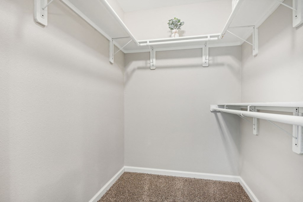 a spacious walk in closet in a home with white walls and a roll in shower at The Glen at Highpoint, Dallas, 75243
