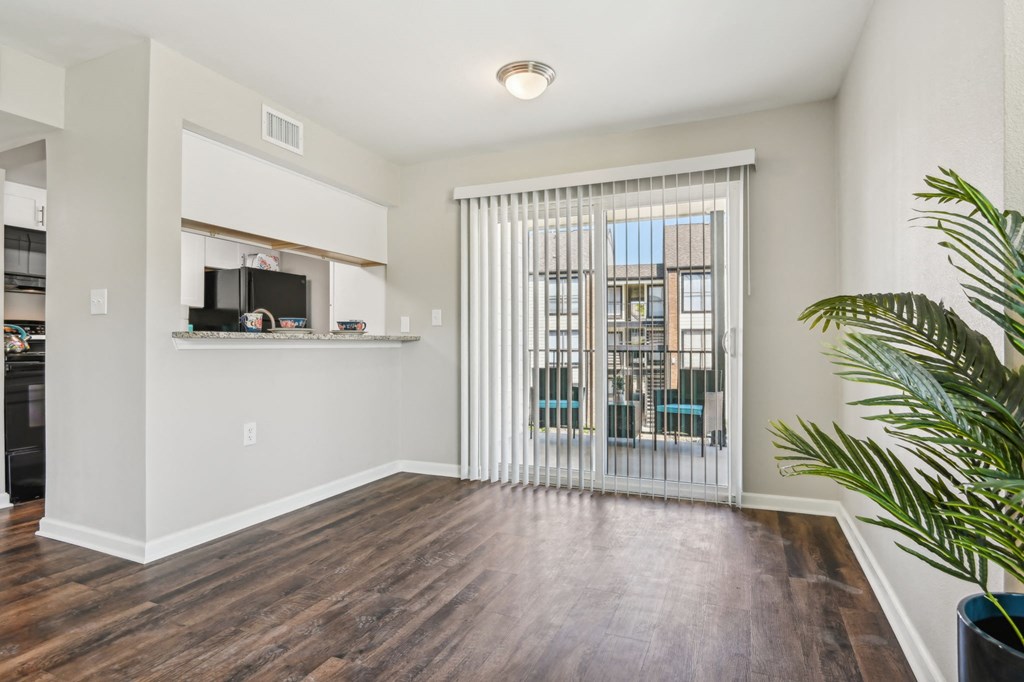 a living room with a sliding glass door and a window at The Glen at Highpoint, Dallas, 75243