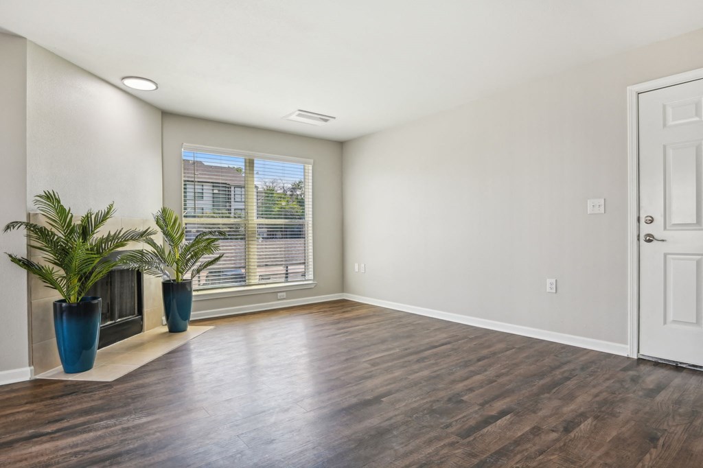 an empty living room with a window and a door at The Glen at Highpoint, Dallas, 75243