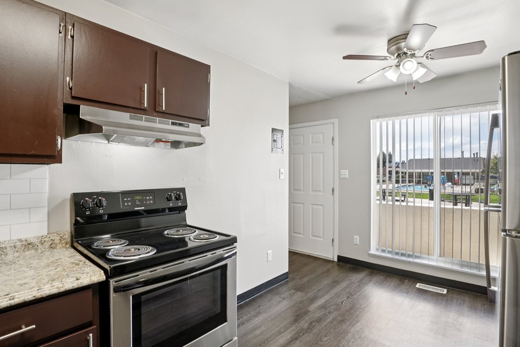 A kitchen with a black stove top oven and a fan ceiling light.at Aspen Townhomes, Colorado Springs, CO