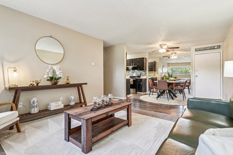 A living room with a wooden coffee table and a mirror on the wall.