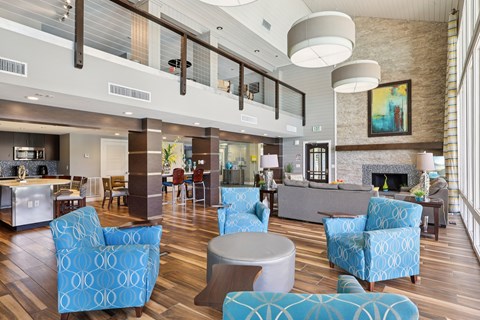 A living room with blue chairs and a fireplace.