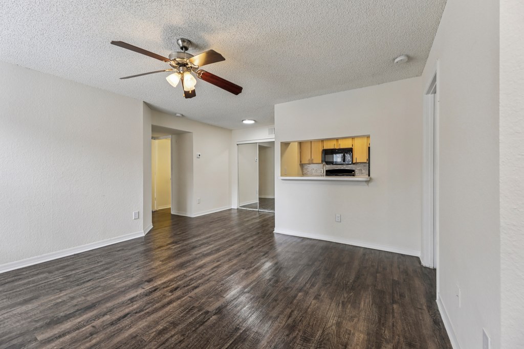 A room with a ceiling fan and wooden flooring. at University Park Apartments, Orlando, FL