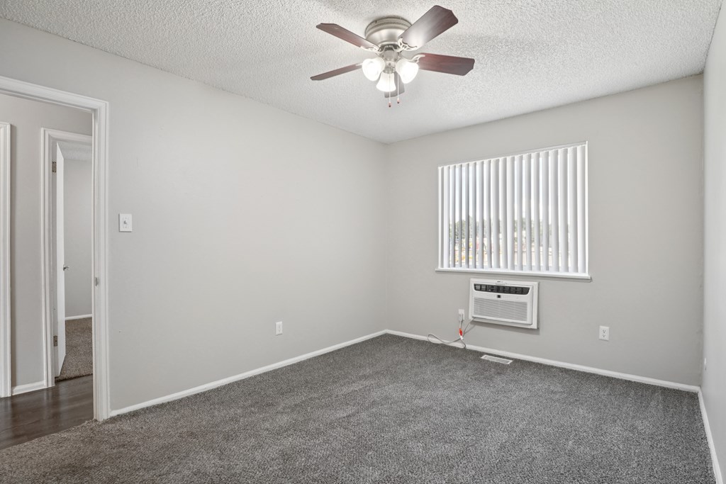A room with a ceiling fan and a window with blinds.at Aspen Townhomes, Colorado Springs, 80909