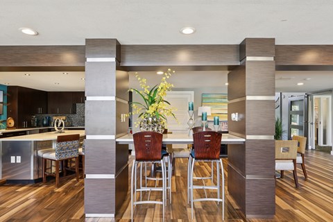A modern kitchen with a bar area and a dining table set up.