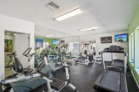 A gym with treadmills, exercise bikes, and other equipment.