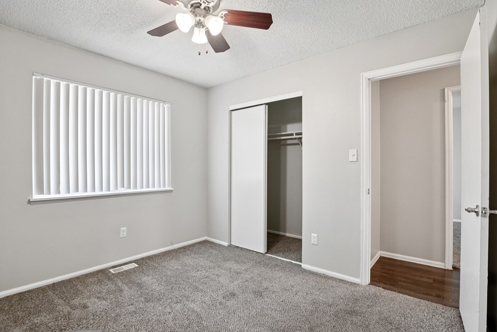 A room with a ceiling fan and a window with blinds.at Aspen Townhomes, Colorado Springs, 80909