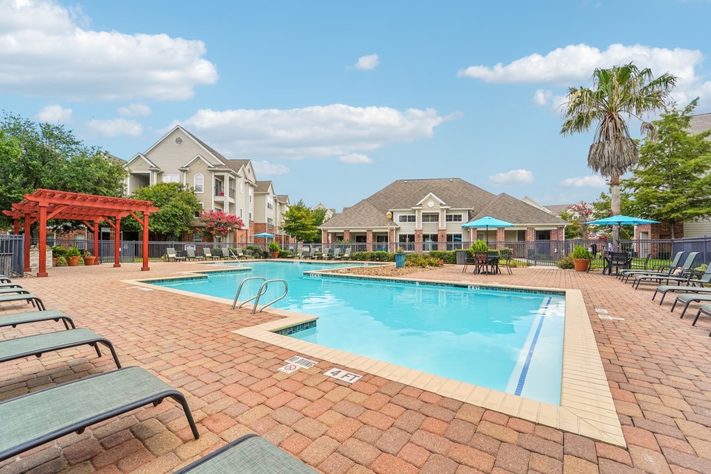 A pool surrounded by lounge chairs and umbrellas.at Kingwood Glen, Texas