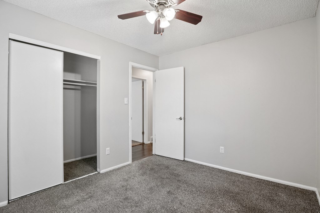 A room with a ceiling fan and carpeted floor. at Aspen Townhomes, Colorado Springs, 80909