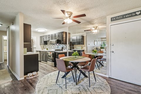 A kitchen with a dining table and chairs in the middle of the room.